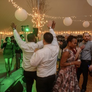 Guests dancing under twinkle lights at a lively Waterville Valley wedding celebration.