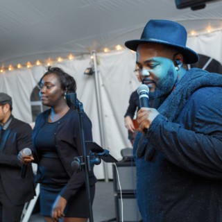Live band performing under string lights at a Waterville Valley wedding celebration.