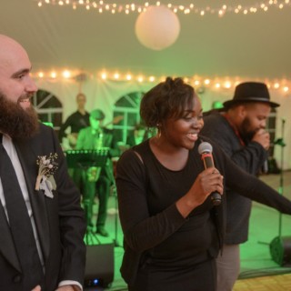 Joyful wedding reception with live band, laughter, and warm lights in Waterville Valley.