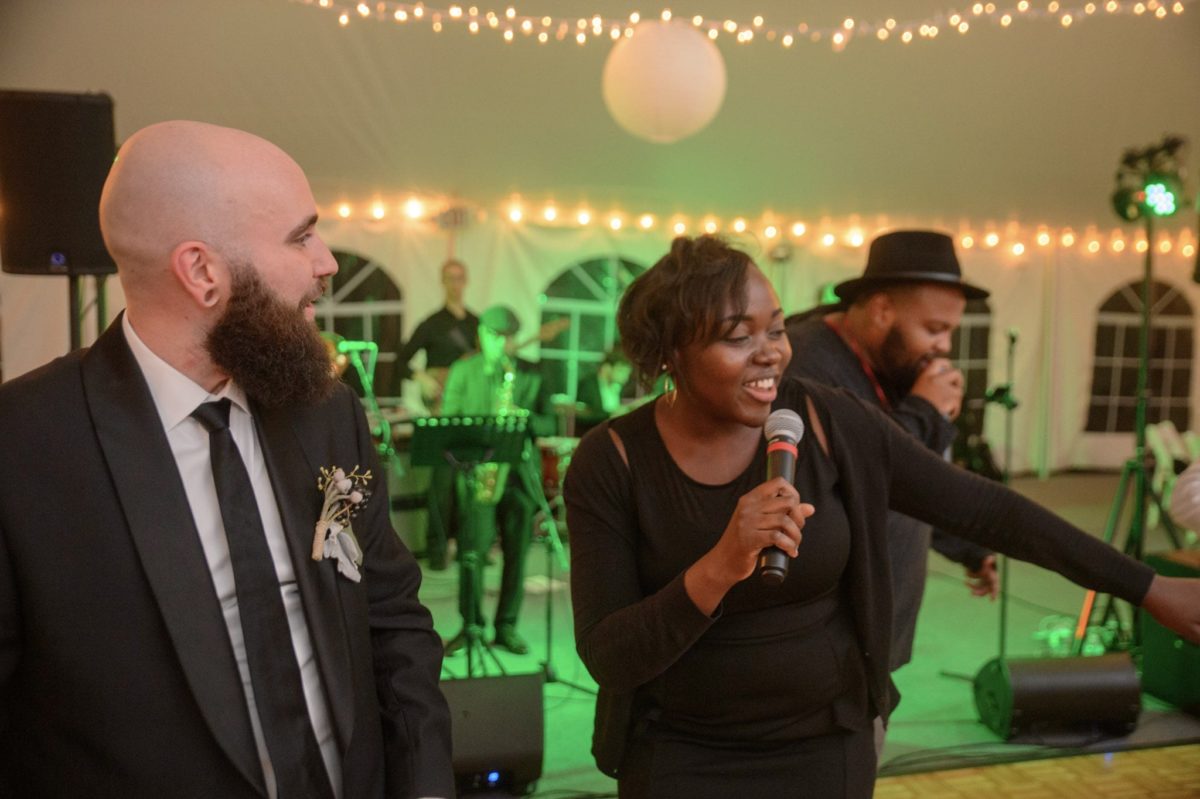 Guests singing and celebrating at a lively Waterville Valley wedding reception with live music.