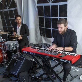 Small live band performing under white event tent at night in Waterville Valley, New Hampshire.