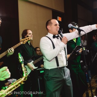 Energetic wedding band performing at Hyatt Regency Boston Harbor with lively singer and musicians.