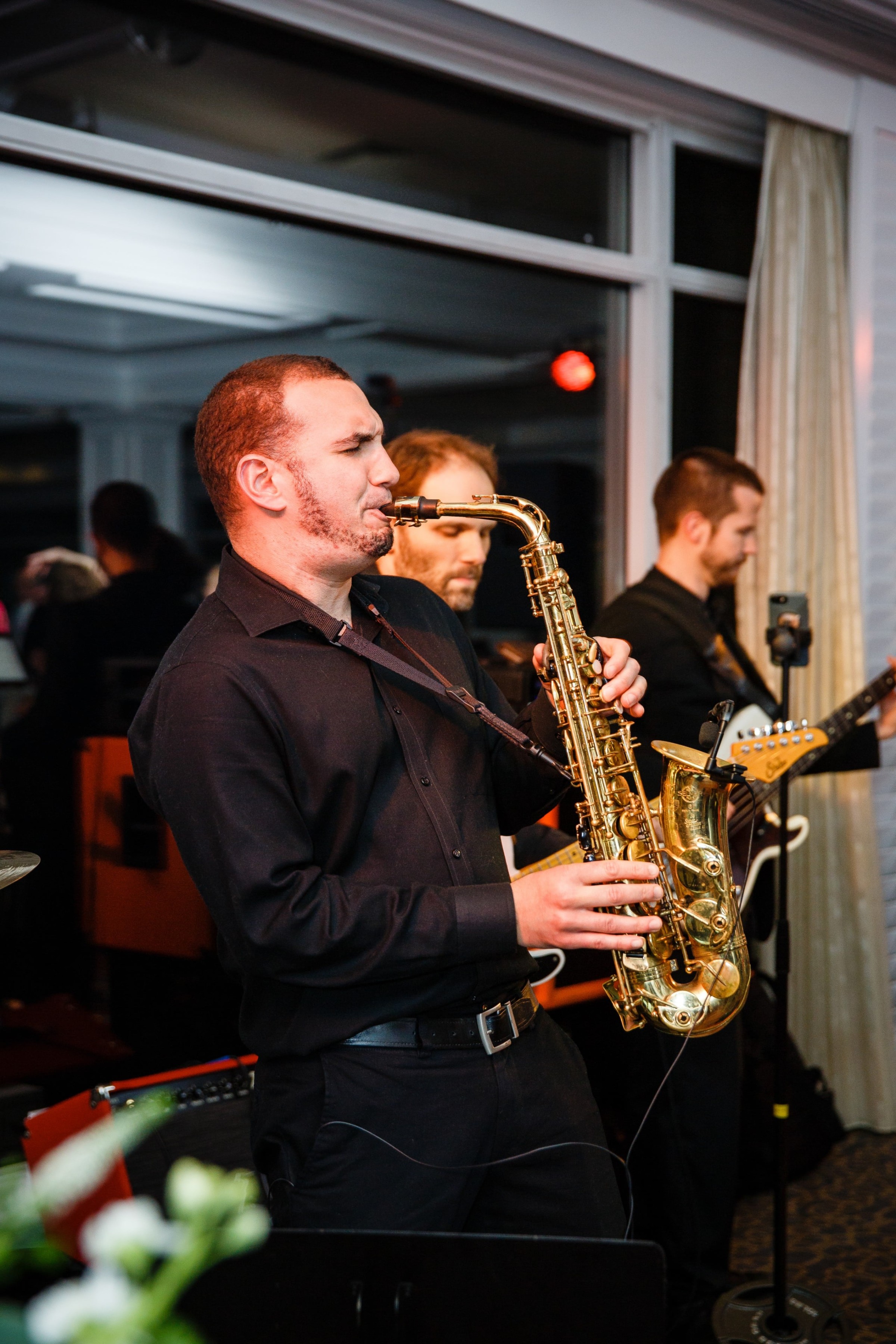 Jazz saxophonist performing live with band at elegant indoor wedding reception in Mashpee, Massachusetts.