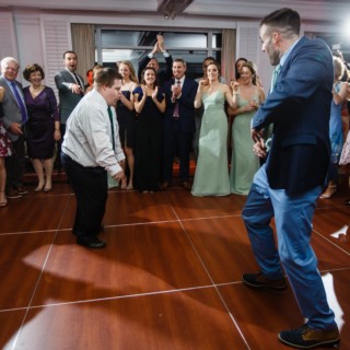 Two men dancing joyfully at a lively Willowbend Country Club wedding in Mashpee, Massachusetts.