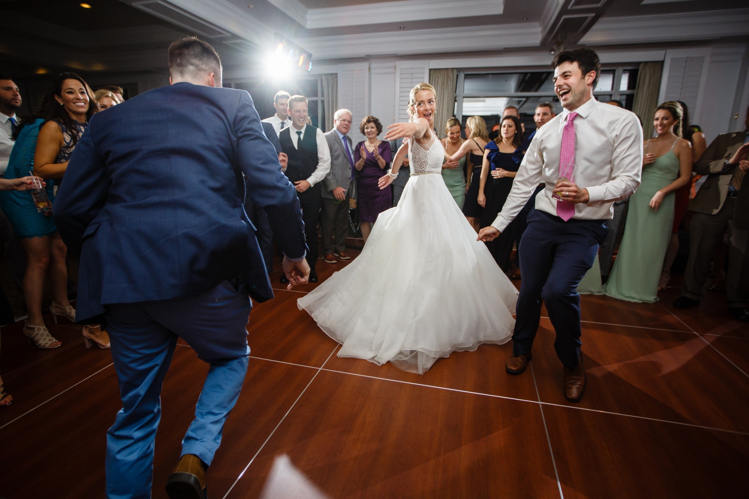 Bride dancing joyfully with guests at Willowbend Country Club wedding reception in Mashpee, Massachusetts.