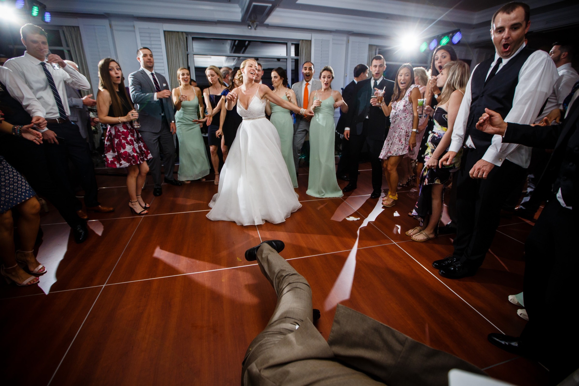 Bride laughing with guests on dance floor at lively Willowbend Country Club wedding reception.