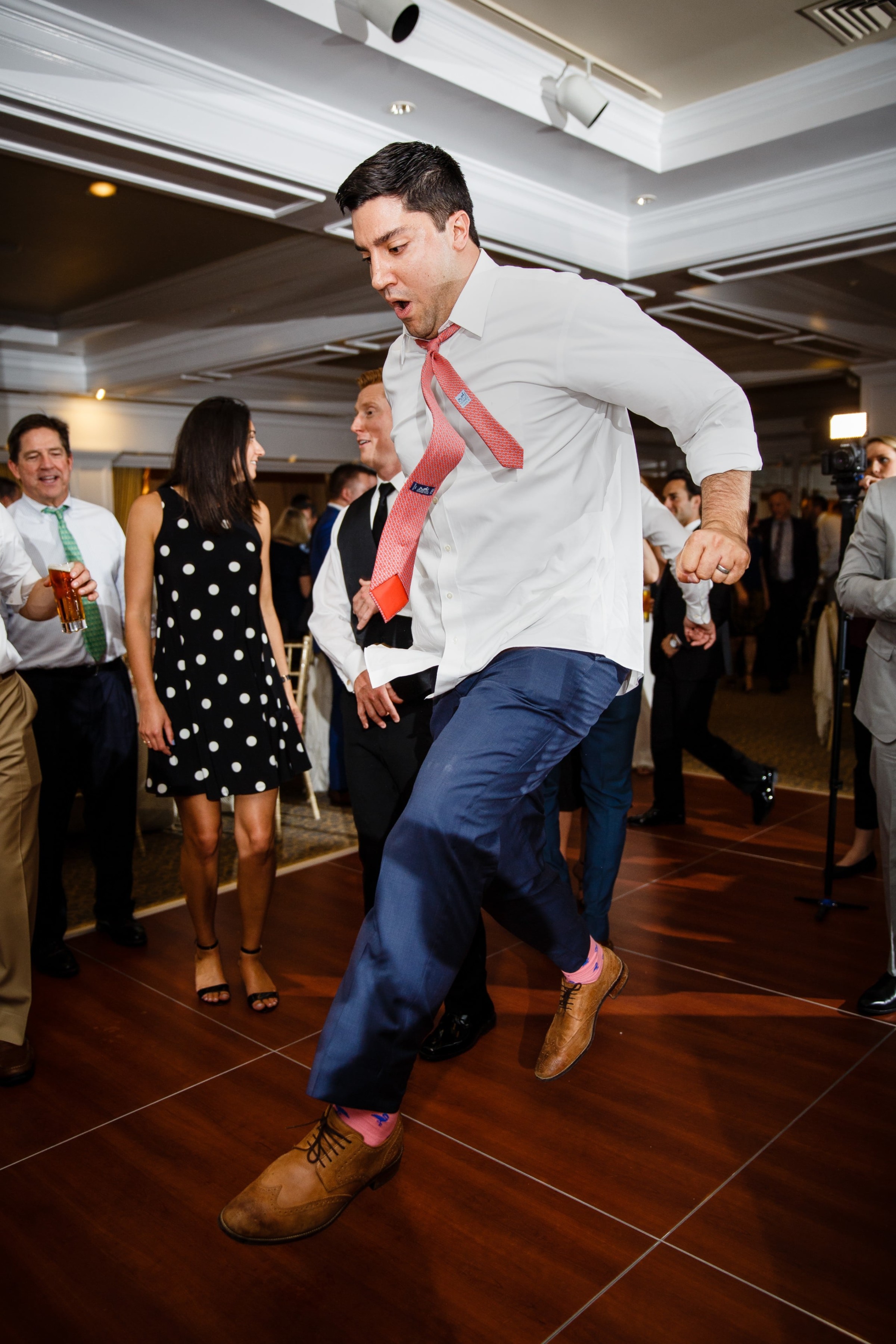 Man jumping mid-dance at lively Willowbend Country Club wedding reception in Mashpee, Massachusetts.