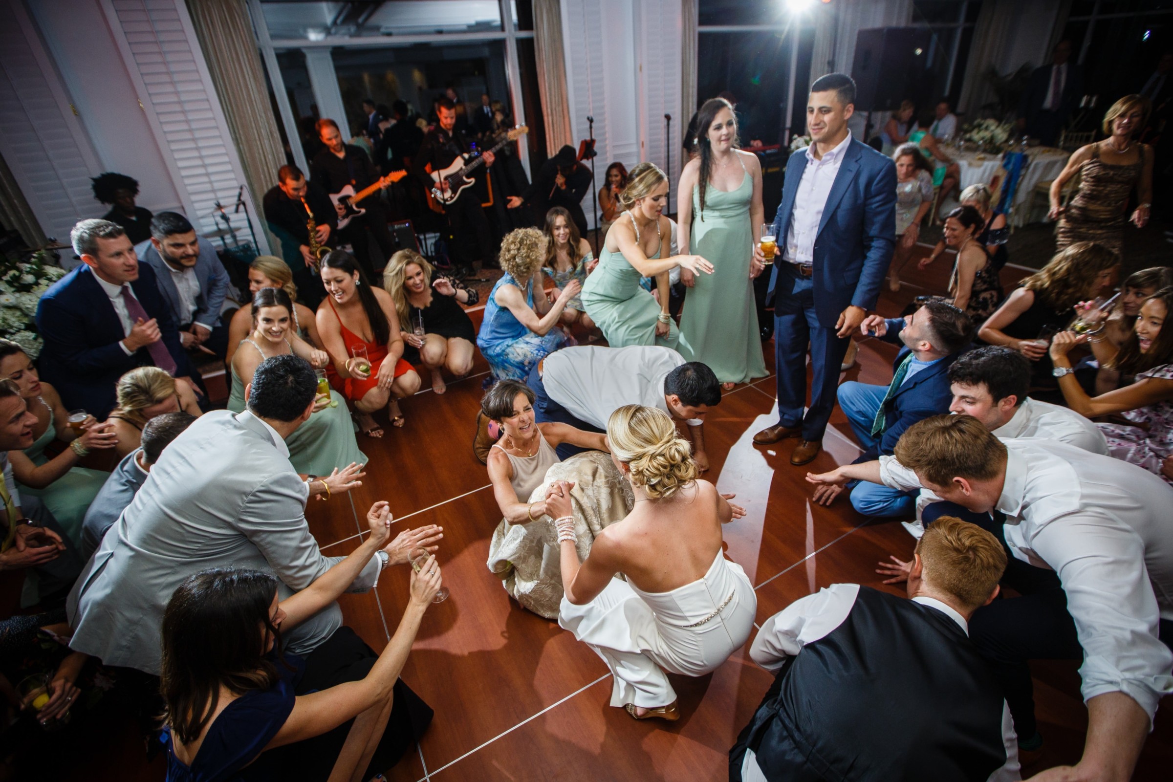 Bride dancing joyfully surrounded by guests at lively Willowbend Country Club wedding reception.