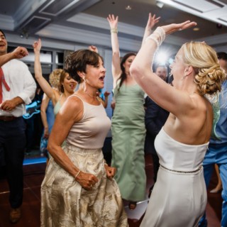 Bride dancing joyfully with guests at lively Willowbend Country Club wedding reception in Mashpee.