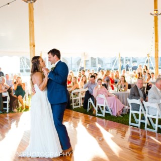 Bride and groom share a romantic first dance under a glowing white wedding tent in Newport.