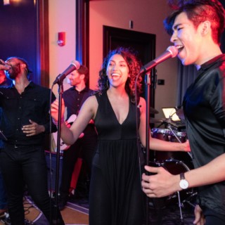 Live wedding band performing with vibrant lights at Boston’s Liberty Hotel reception.