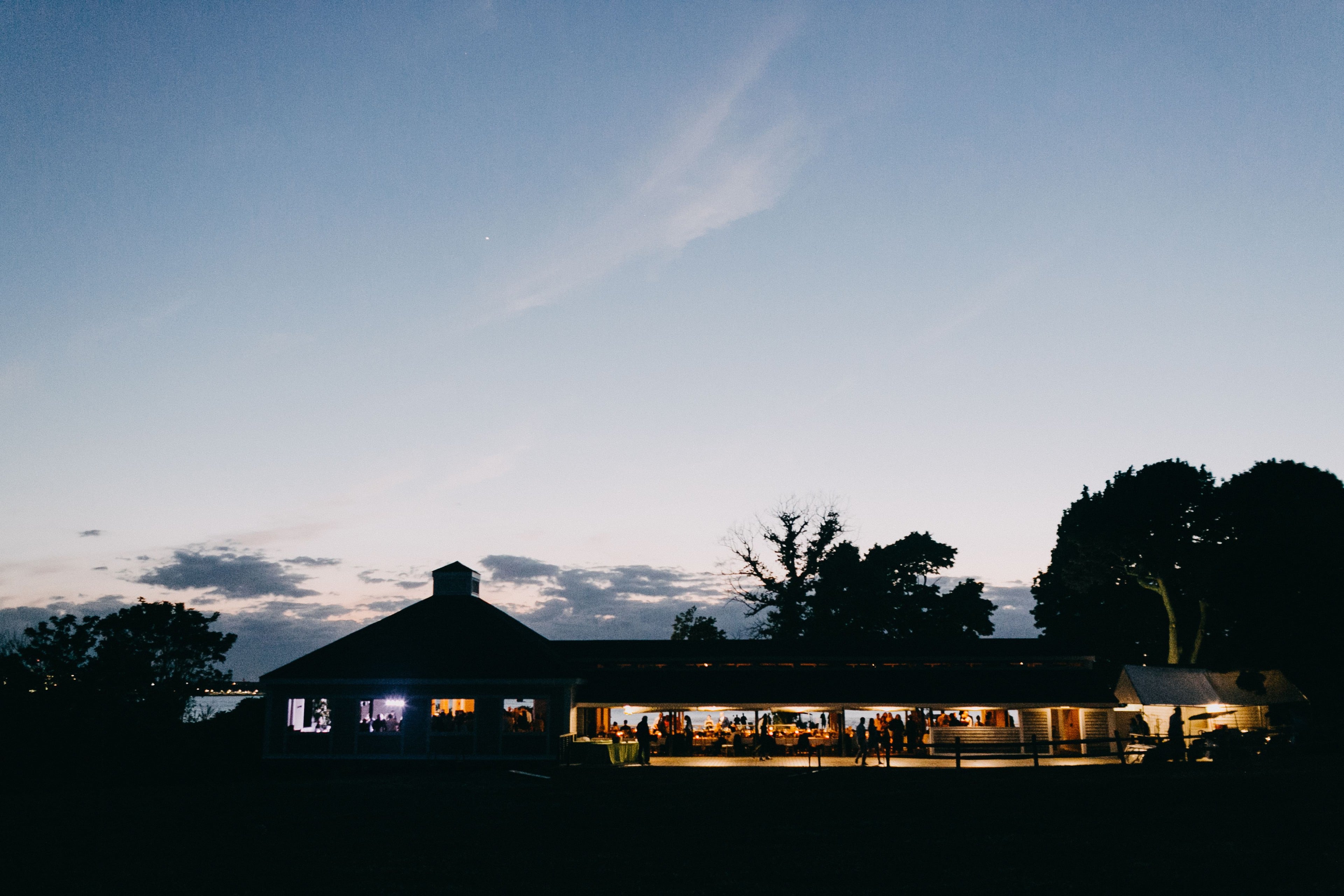 Rustic barn wedding on Thompson Island glowing at sunset near Boston, Massachusetts.