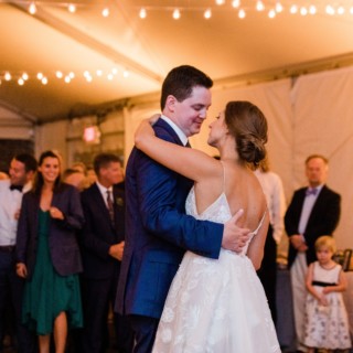 Bride and groom share a romantic first dance under twinkling lights at Elm Bank wedding.