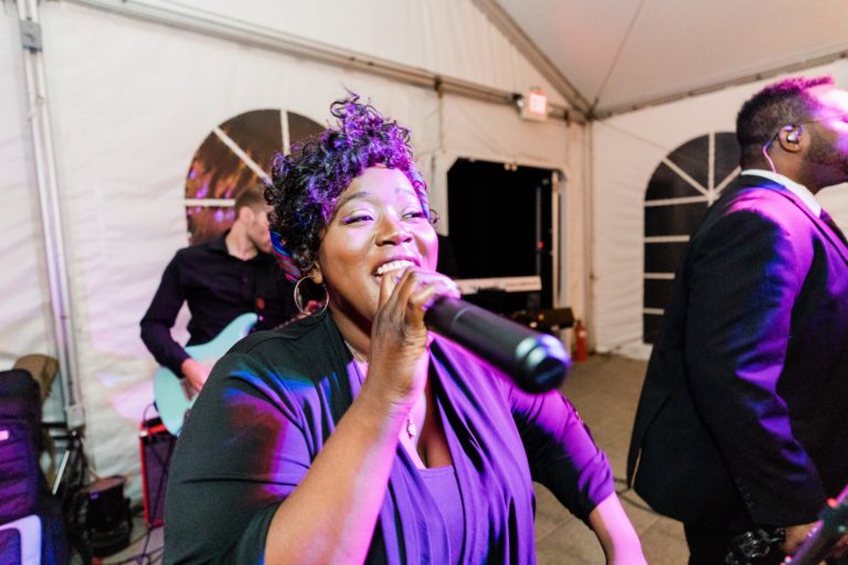 Joyful live band performing under colorful lights at Elm Bank wedding in Wellesley, Massachusetts.