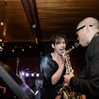 Singer and saxophonist performing passionately under warm lights at an intimate Shelburne Farms wedding.