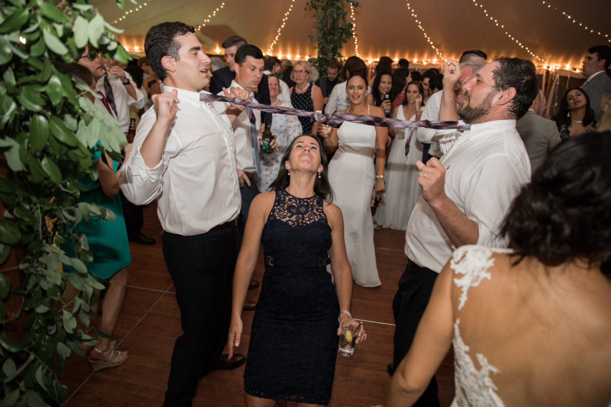 Guests laugh and dance under string lights during a joyful Twin Lake Village wedding celebration.