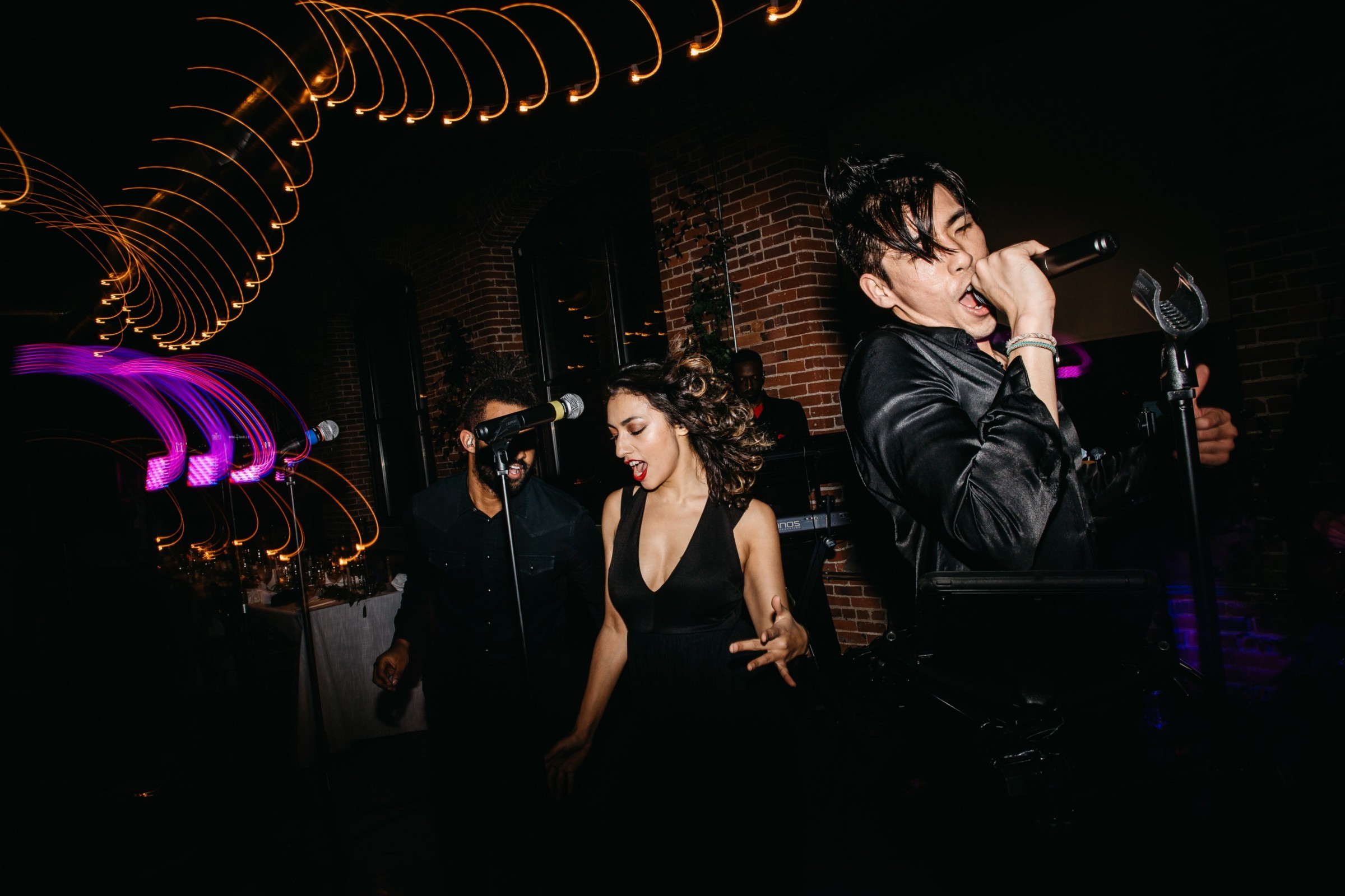 Energetic live band performing at Dover venue with passionate singers and vibrant stage lighting.