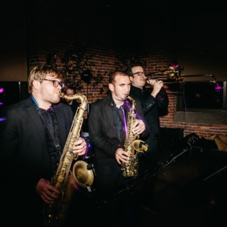 Jazz trio performing indoors with saxophones and trombone at Dover wedding reception.