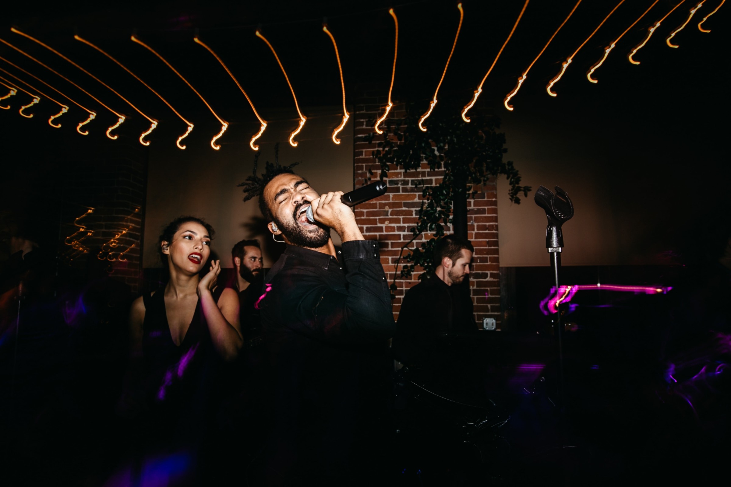 Passionate singer performing live at rustic Dover venue with warm lighting and energetic atmosphere.