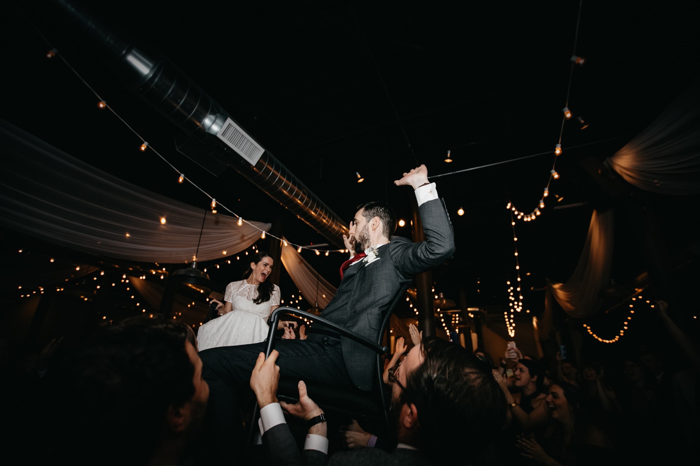 Bride and groom lifted during joyful Hora dance at Rivermill wedding in Dover, New Hampshire.