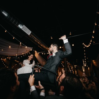 Bride and groom lifted during joyful Hora dance at Rivermill wedding in Dover, New Hampshire.