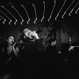Passionate black-and-white live band performance with emotional singer and dramatic lighting.