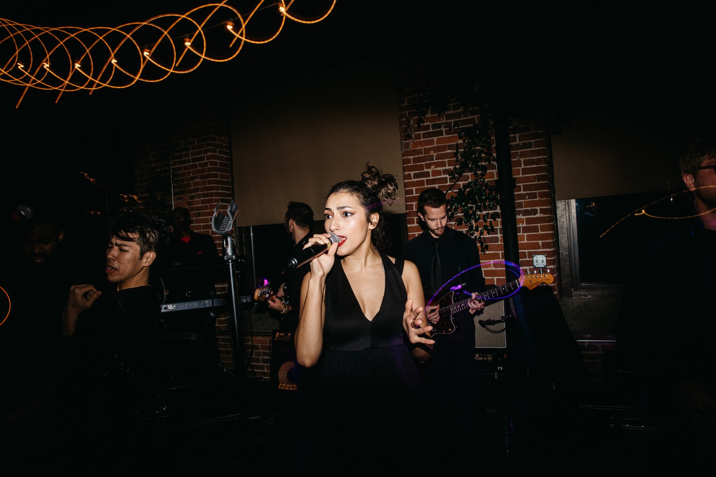 Female jazz singer performing live with band under warm lights at Rivermill Dover Landing.