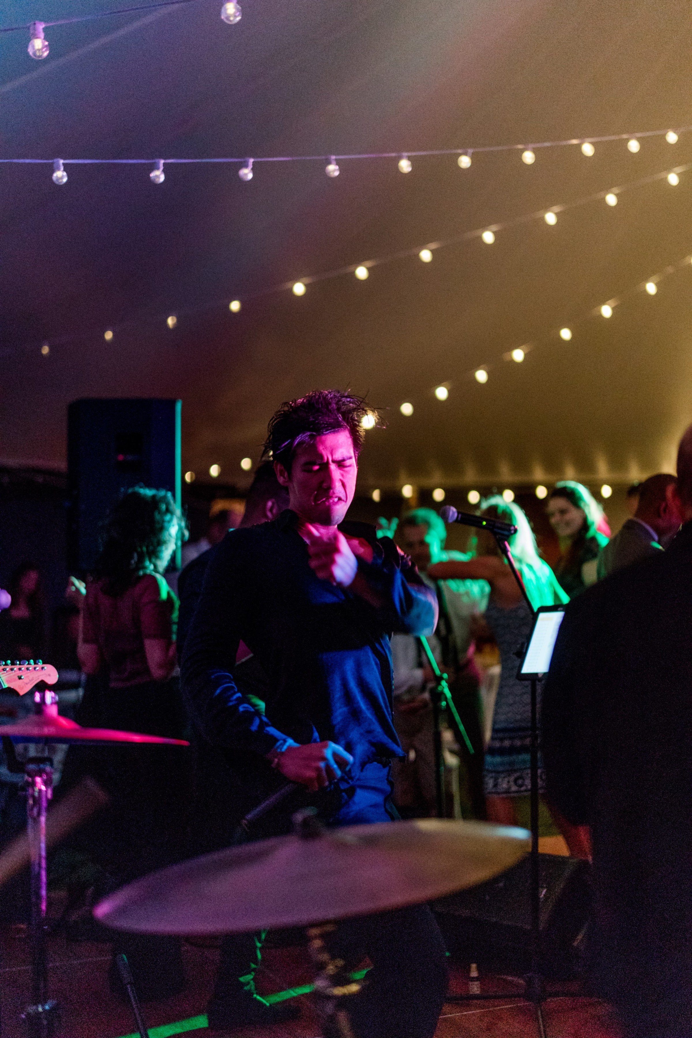 Passionate singer performing under colorful lights at a lively Twin Lakes Village wedding reception.