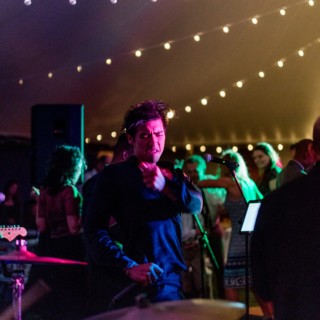 Passionate singer performing under colorful lights at a lively Twin Lakes Village wedding reception.