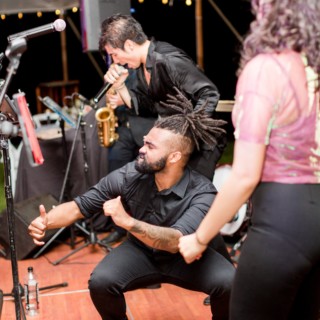 Energetic live wedding band performance with guests dancing under warm string lights in New London, NH.