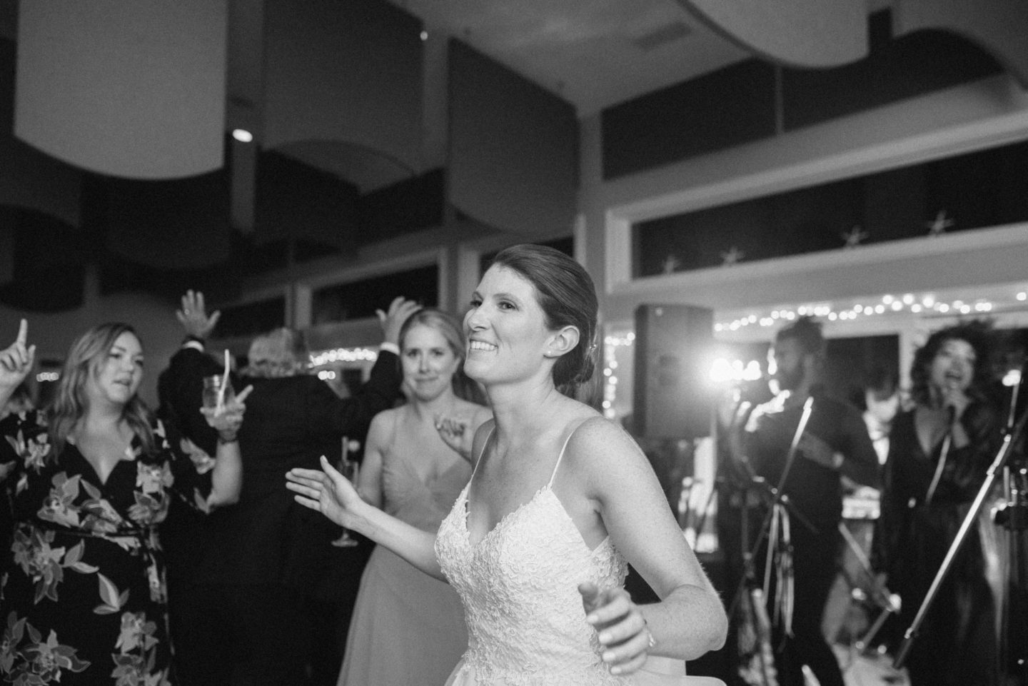 Black-and-white photo of energetic singers performing live at West Dennis Yacht Club wedding.