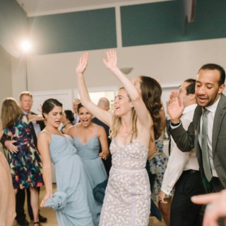 Guests dancing joyfully at a lively West Dennis Yacht Club wedding reception in Massachusetts.