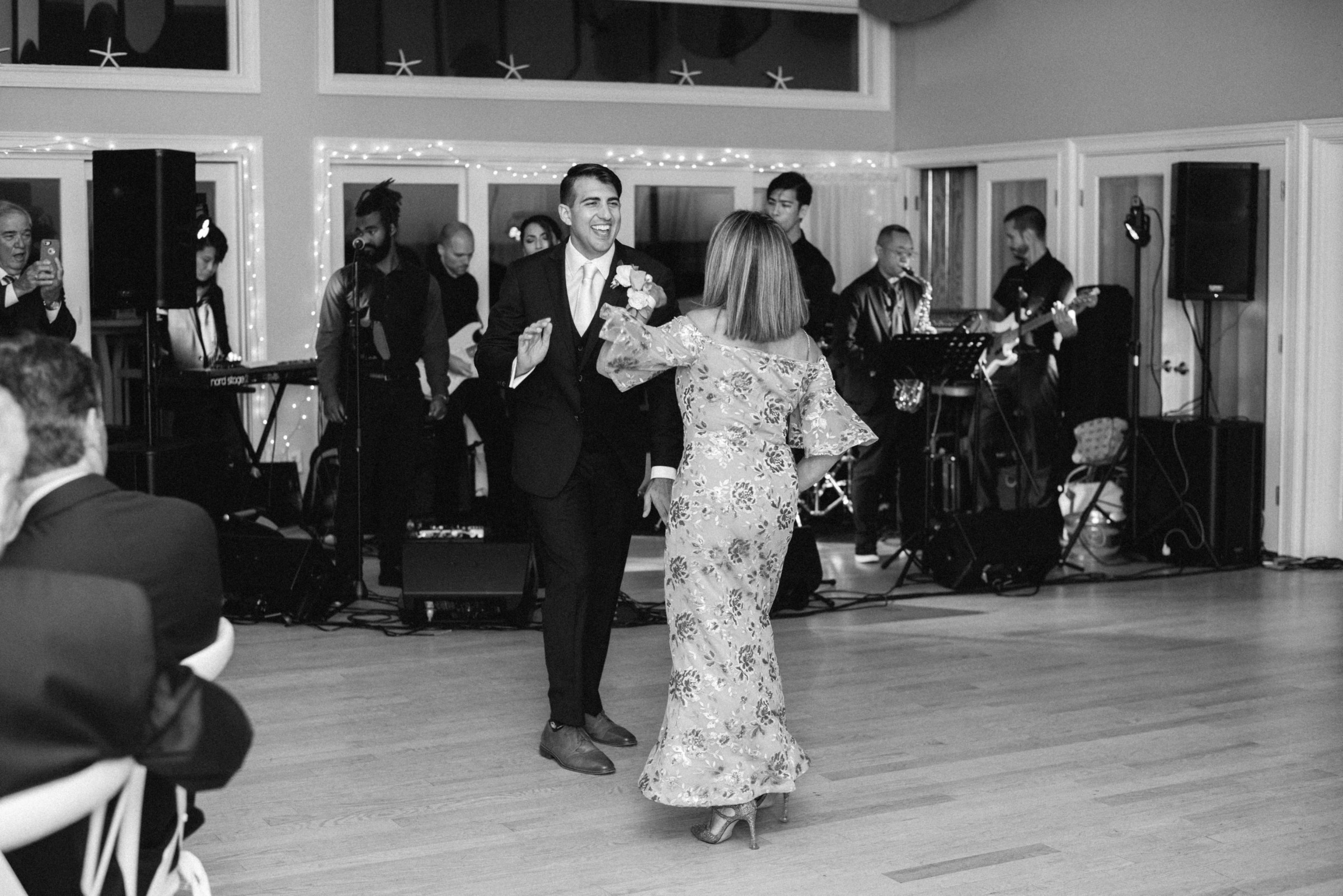 Groom joyfully dances with his mother at elegant West Dennis Yacht Club wedding celebration.