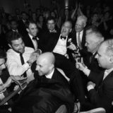 Two grooms lifted on chairs during joyful Hora dance at elegant Newport wedding celebration.