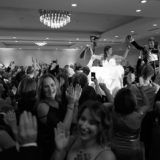 Bride and groom lifted during joyful Jewish hora dance at Newport Marriott wedding celebration.