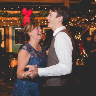 Mother and son dancing joyfully at a festive winter wedding in Brownfield, Maine.