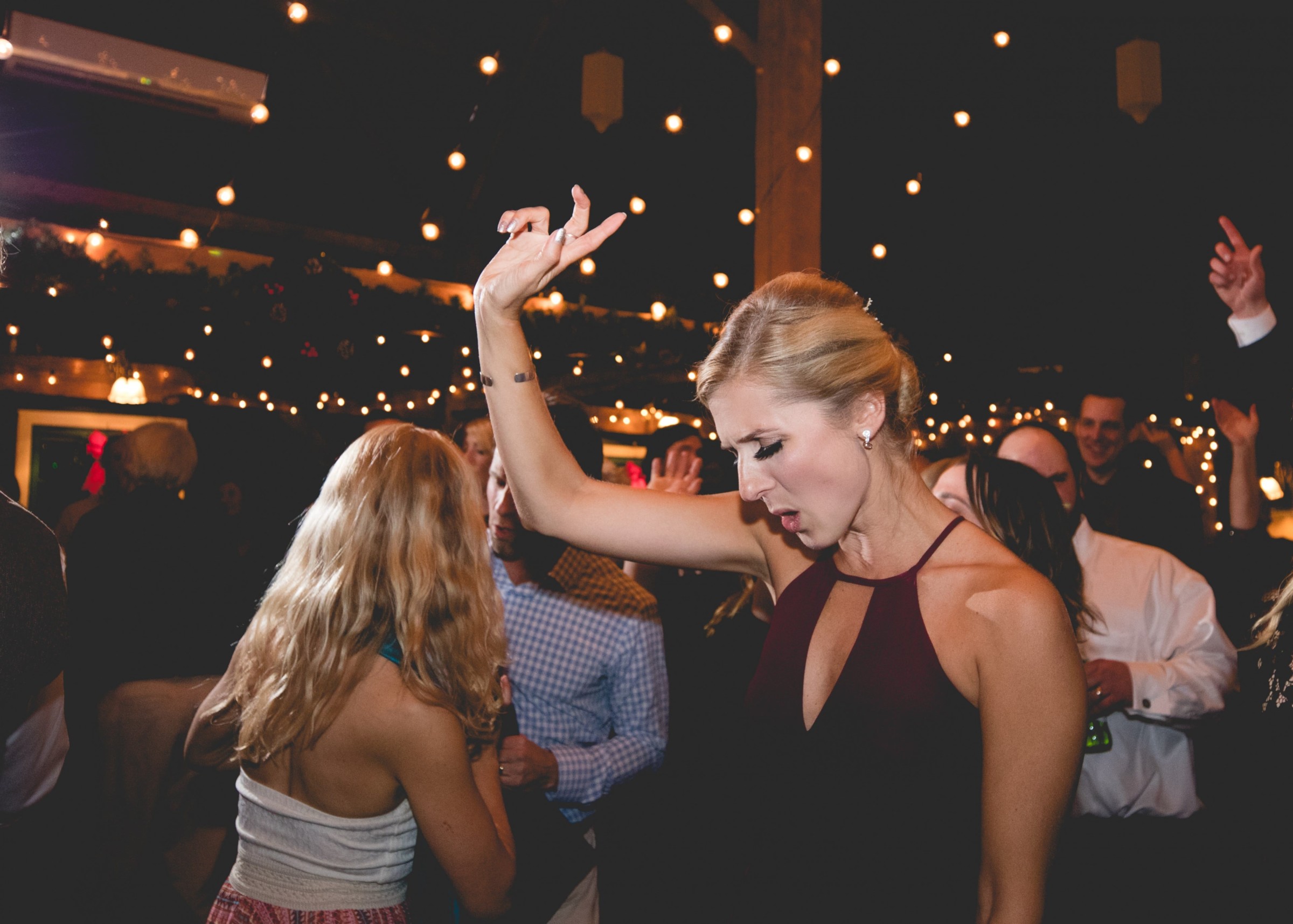 Woman dancing under warm string lights at a lively Stone Mountain Arts Center wedding.