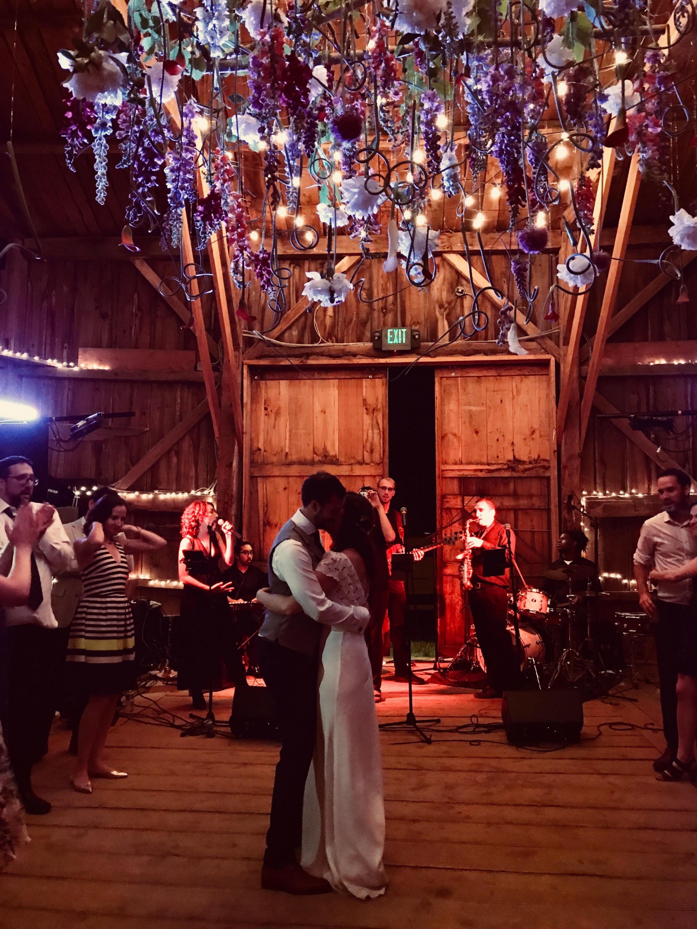 Bride and groom share a romantic first dance in a flower-lit barn wedding at Broadturn Farm.