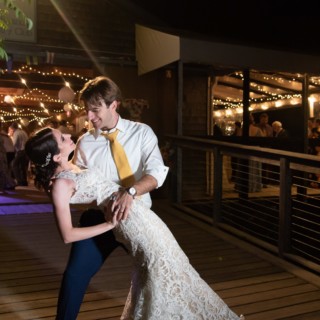 Bride and groom share a romantic dance under warm string lights at Chequessett Yacht Club wedding.