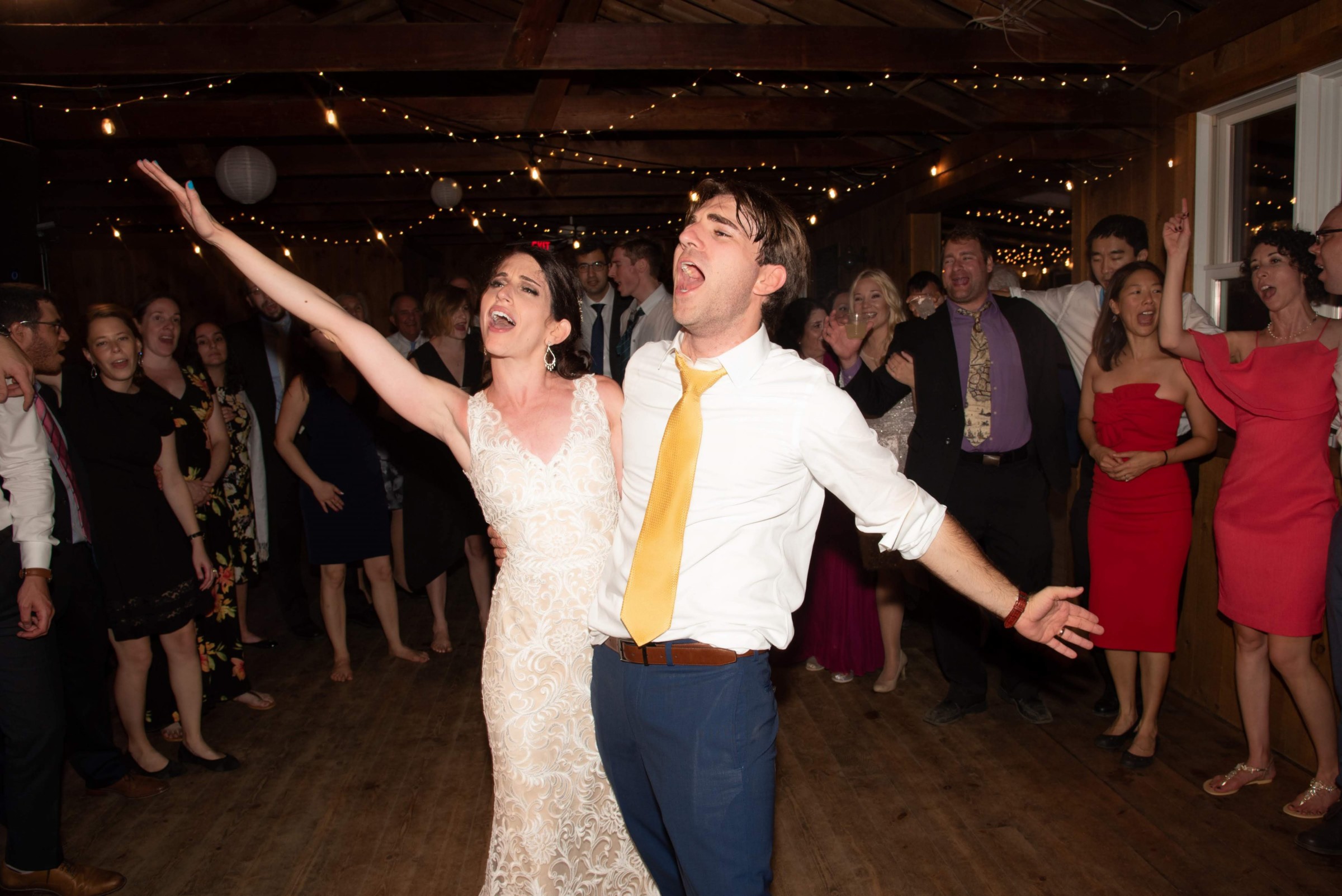Bride and groom celebrating joyfully on the dance floor at Chequessett Club wedding reception.