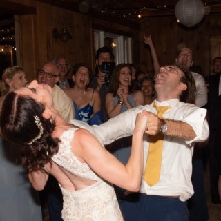Bride and groom dancing joyfully at rustic Chequessett Yacht Club wedding reception in Wellfleet, MA