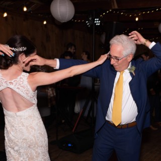 Father-daughter dance at Chequessett Yacht Club wedding in Wellfleet, MA under warm string lights.