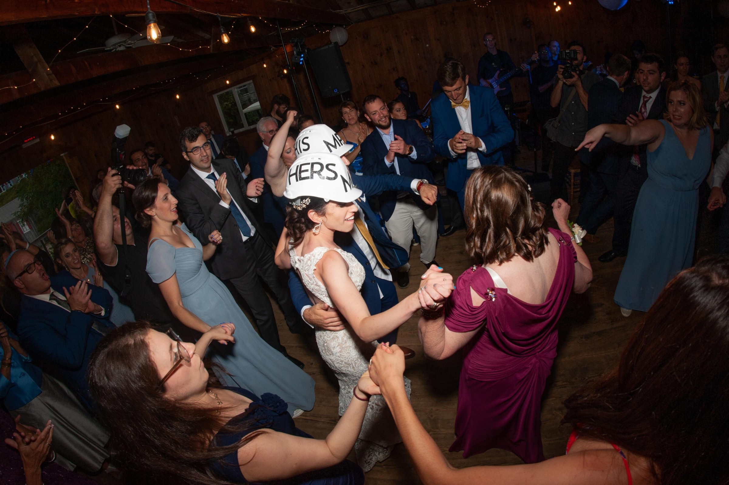 Bride and groom dancing joyfully with guests at rustic Chequessett Club wedding in Wellfleet, Massachusetts.