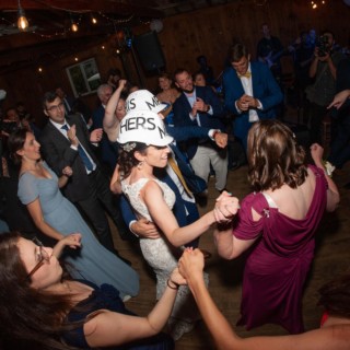 Bride and groom dancing joyfully with guests at rustic Chequessett Club wedding in Wellfleet, Massachusetts.