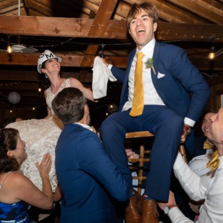 Bride and groom lifted during joyful Hora dance at Chequessett Yacht & Country Club wedding.