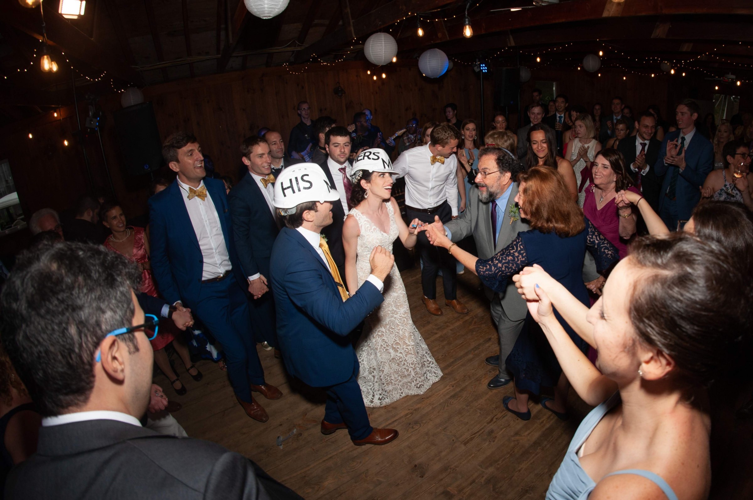 Bride and groom dancing at rustic Chequessett Yacht Club wedding surrounded by joyful guests.
