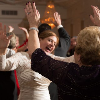 Bride and guest dancing joyfully at Courtyard by Marriott Boston Downtown wedding reception.