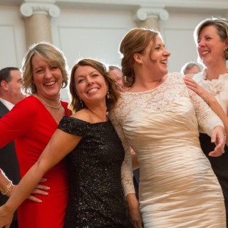 Bride laughing with friends during joyful wedding reception at Courtyard by Marriott Boston Downtown.