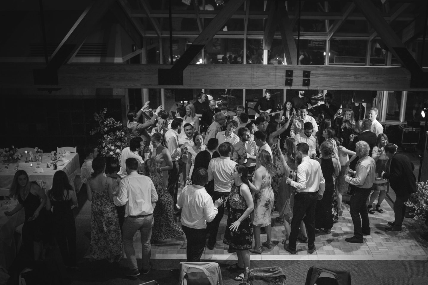 Black and white indoor wedding ceremony in Pomfret Vermont with bride, groom, and floral decor.