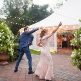 Joyful couple dancing outside glowing wedding tent at Willowdale Estate in Topsfield, Massachusetts.